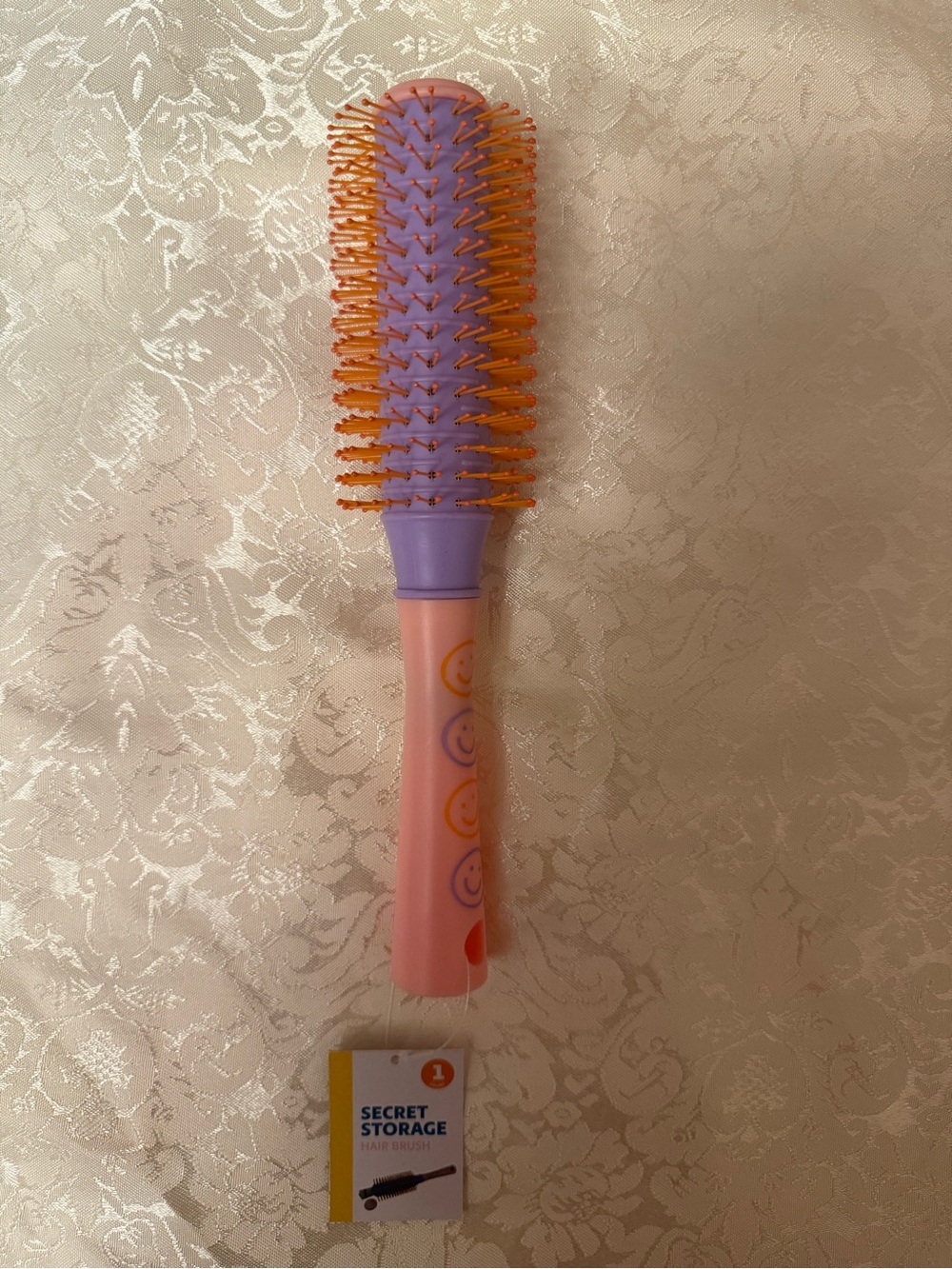 Target Secret Storage Hairbrush features a smiley-face pattern on the pink handl